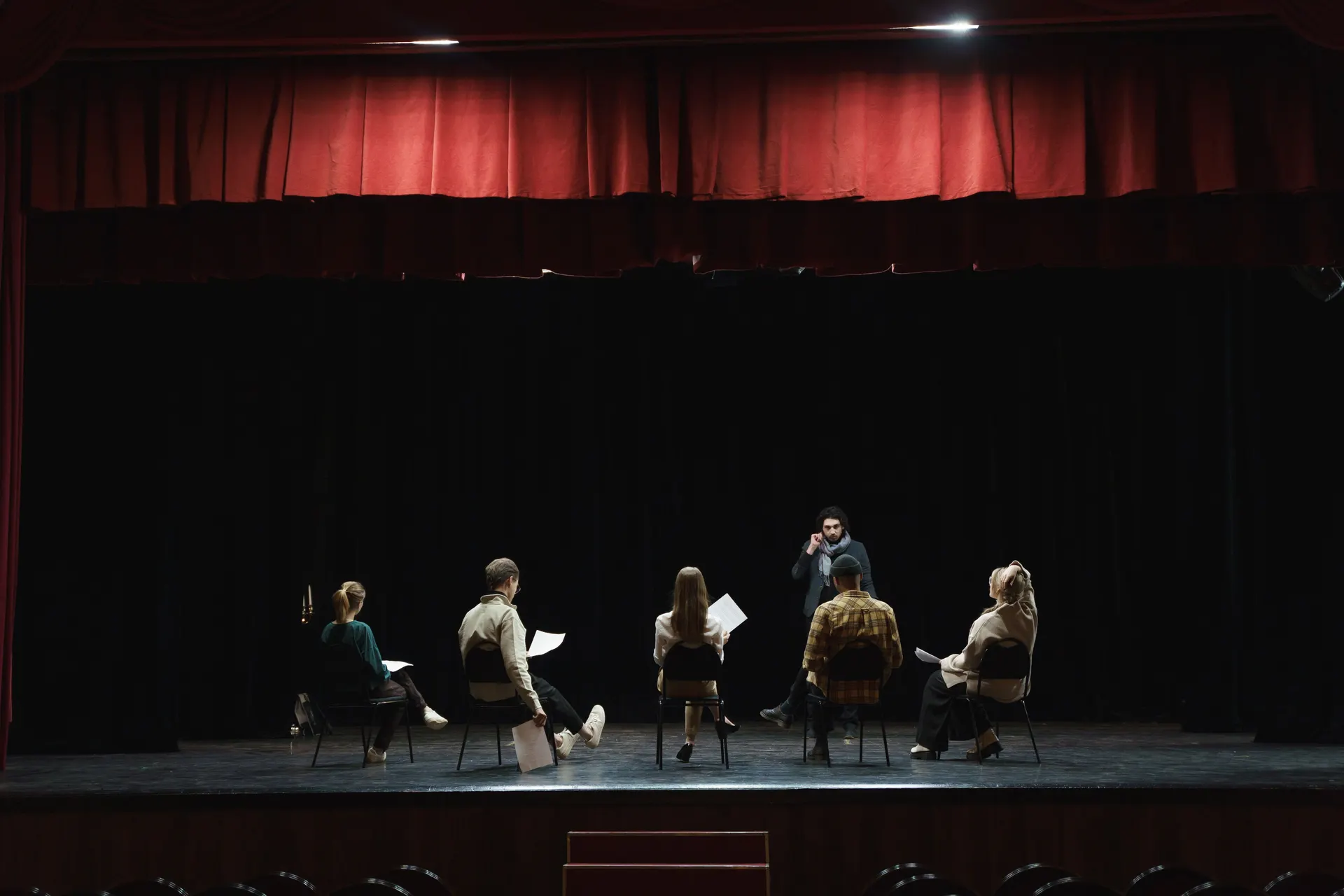 Scena teatralna z czerwoną kurtyną podczas warsztatu aktorskiego